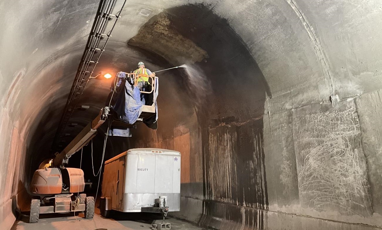 A worker power washes the inside of the inbound Armstrong Tunnel in Pittsburgh